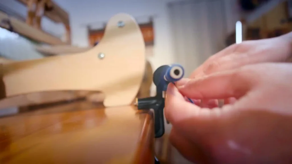 Η Εργαστίνη περνάει τα νήματα από το χτένι του αργαλειού